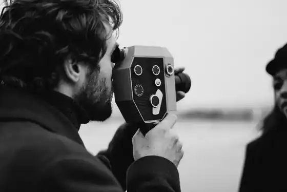 Videographer filming a wedding couple on a Bali beach with a cinema camera