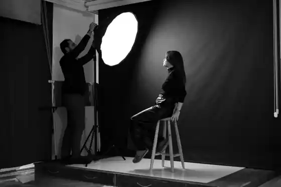 Professional photographer directing a portrait shoot with studio lighting