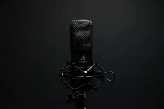 Close-up of a professional podcast microphone on a shock mount in a recording studio