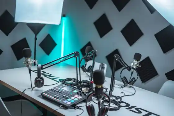 An empty podcast room with two microphones, chairs and acoustic panels, ready for a self-run session