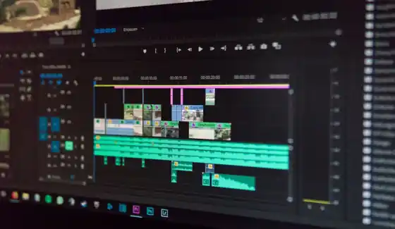 Video editor cutting footage on a multi-monitor editing workstation