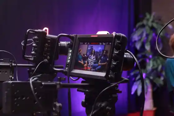 Two camera operators filming an interview in a professional video studio
